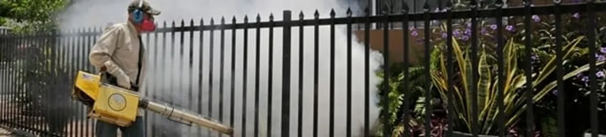 Mosquito control technician fogging a yard perimeter for mosquito reduction in Toledo, OH